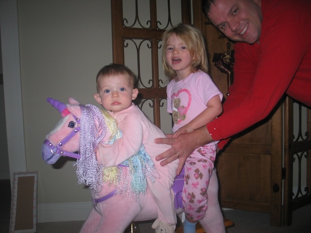 The day after Christmas Paige & Josie ride the unicorn (with pa's help).